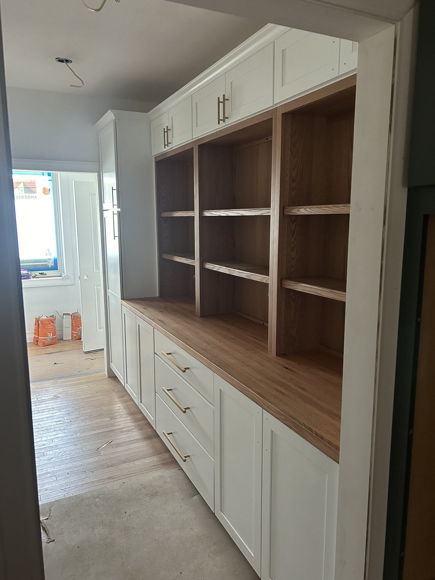 Custom built-in hutch and dry bar with white cabinetry, open display shelving, and a butcher block wood countertop.